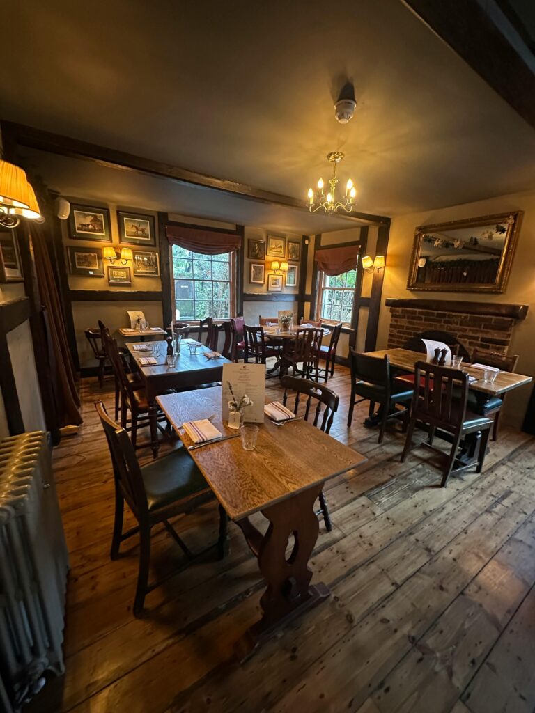 Alternativer Text: Ein Gastraum im rustikalen Stil mit fünf Tischen.